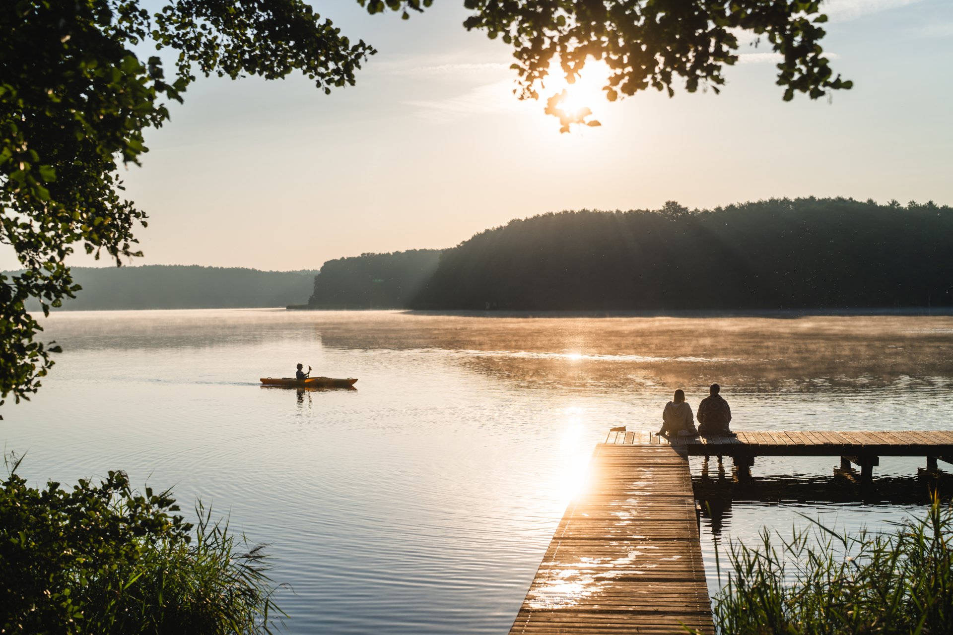 Paar auf dem Steg am Mirower See im Morgenlicht