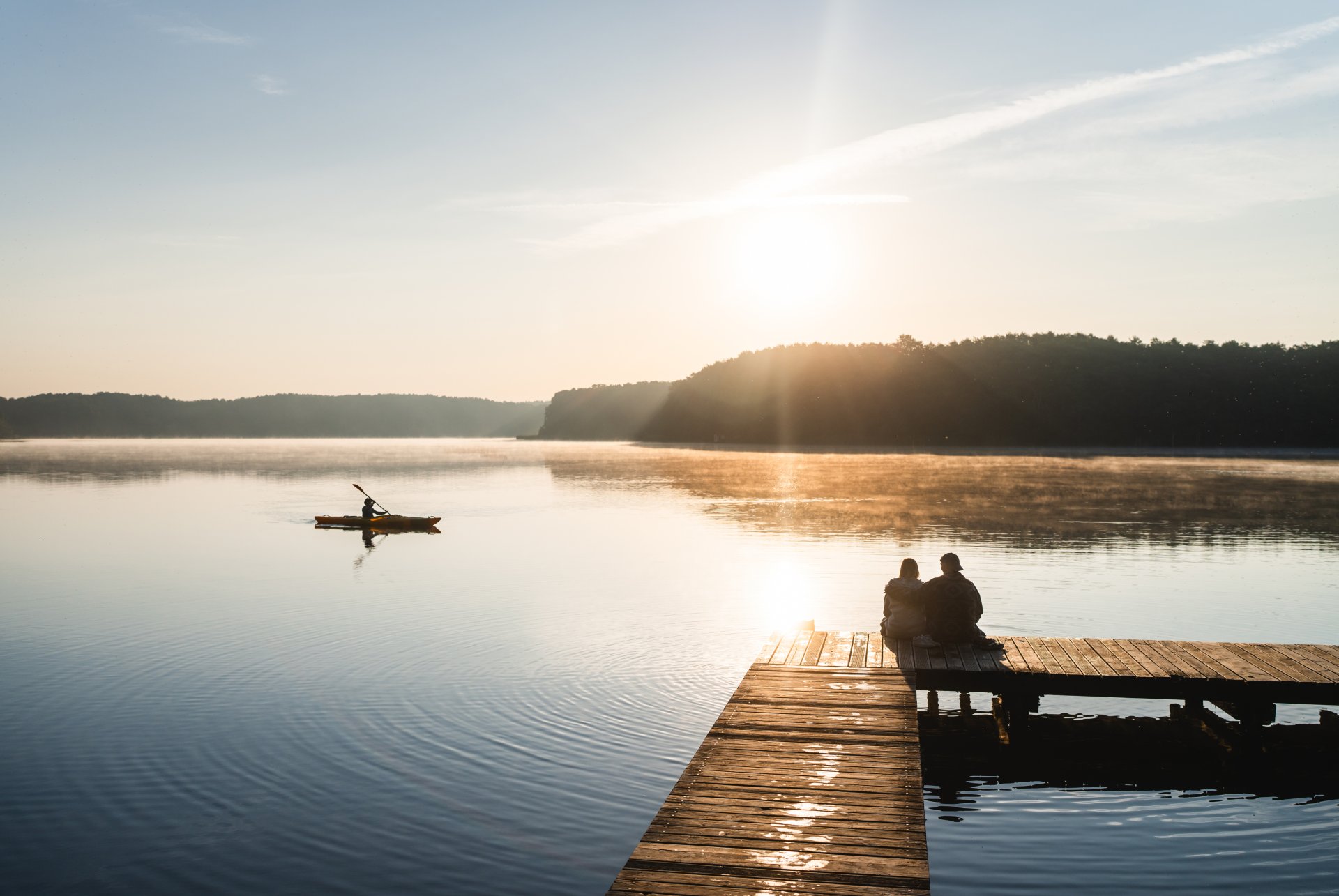 Paar auf dem Steg am Mirower See im Sonnenaufgang